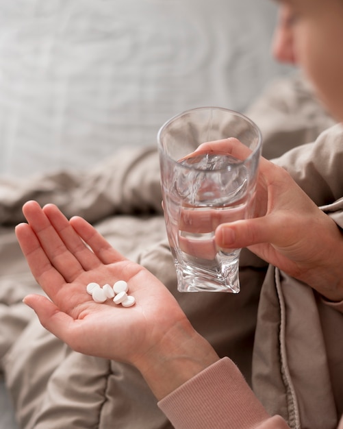 Foto gratuita mujer de alta vista con pastillas en la mano