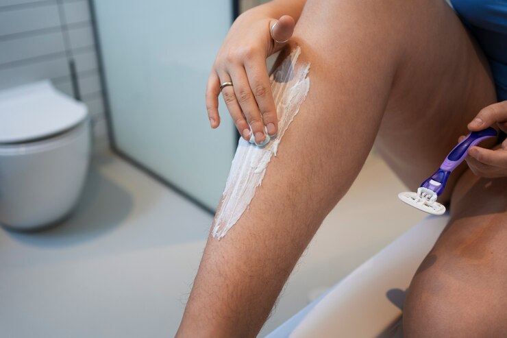 Foto gratuito mujer de alto ángulo afeitándose en casa