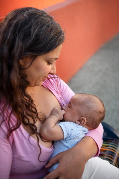 Mujer de alto ángulo amamantando lindo bebé