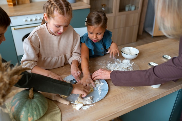 Foto gratuita mujer de alto ángulo ayudando a los niños a cocinar