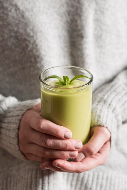 Mujer de alto ángulo con batido verde