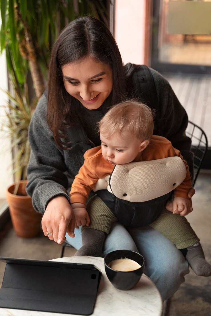 Foto gratuito mujer de alto ángulo con bebé en portabebés