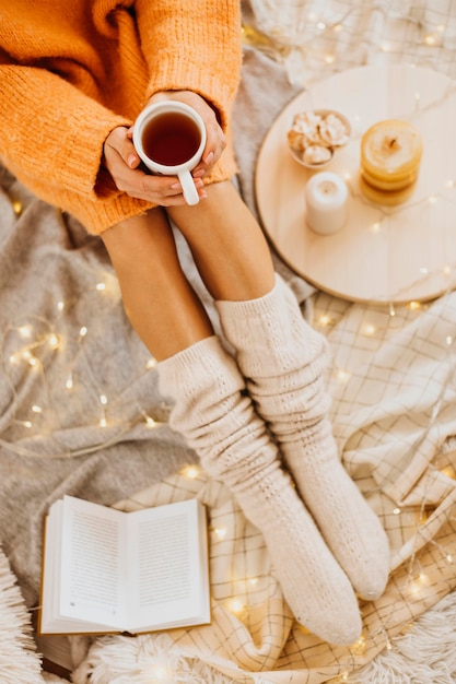 Mujer de alto ángulo disfrutando de las vacaciones de invierno con una taza de té