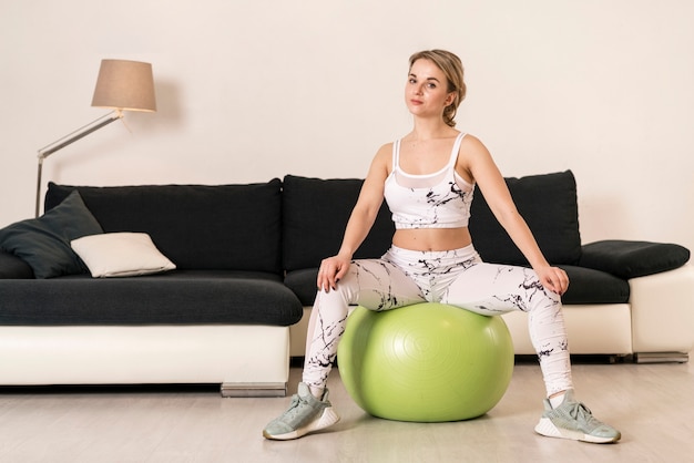 Foto gratuita mujer de alto ángulo de entrenamiento con balón de fitness