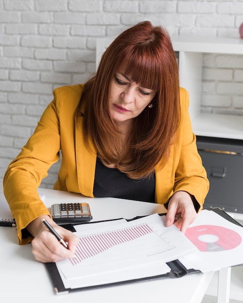 Foto gratuita mujer de alto ángulo escribiendo en hoja de papel