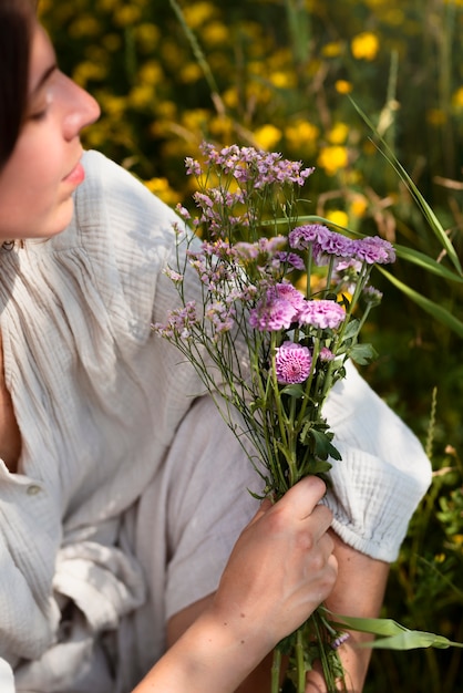 Foto gratuita mujer de alto ángulo con flores moradas