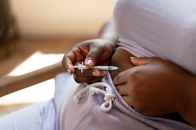 Foto gratuita mujer de alto ángulo inyectando insulina en casa