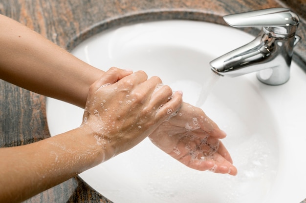 Mujer de alto ángulo, lavarse las manos