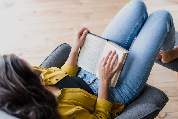 Mujer de alto ángulo leyendo un libro