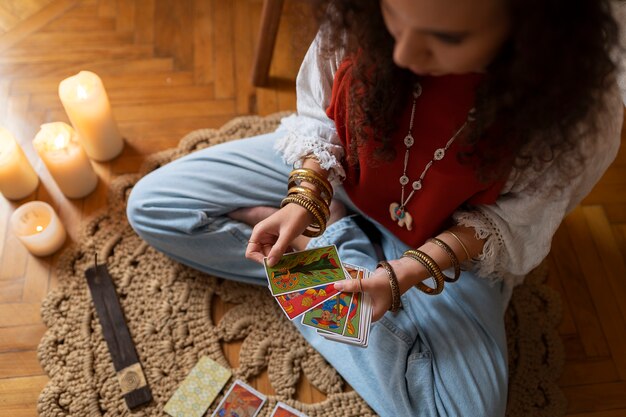 Mujer de alto ángulo leyendo tarot en casa