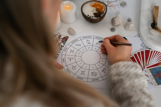 Mujer de alto ángulo leyendo tarot en casa