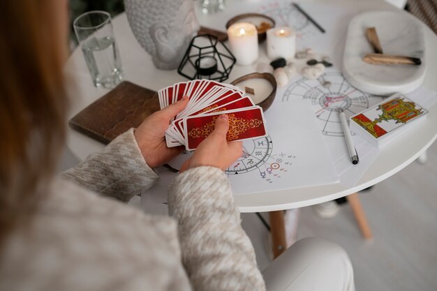 Mujer de alto ángulo leyendo tarot en casa