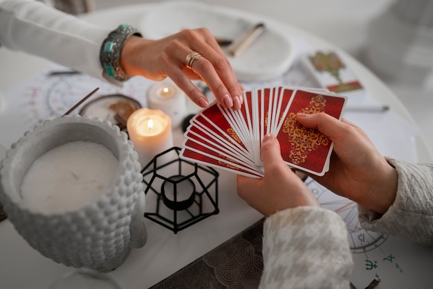 Foto gratuita mujer de alto ángulo leyendo tarot en casa