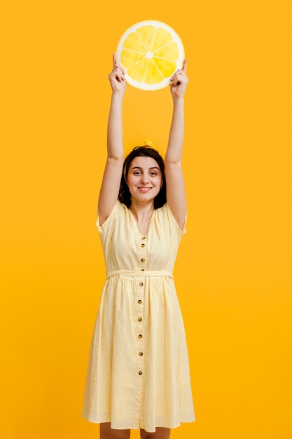 Foto gratuita mujer de alto ángulo con limón gigante