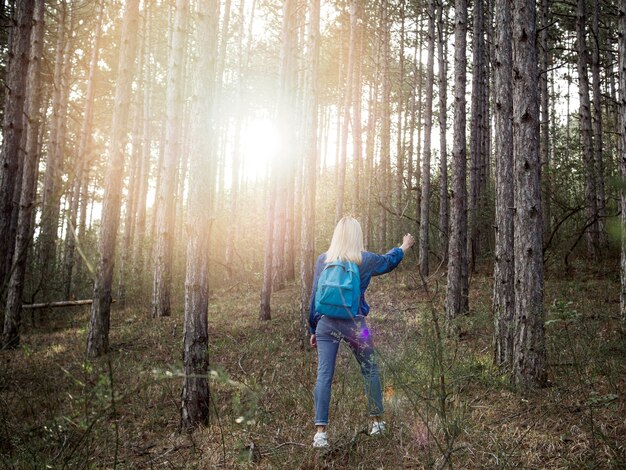 Mujer de alto ángulo con mochila en bosque