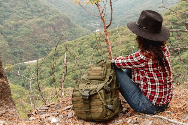 Mujer de alto ángulo con mochila descansando