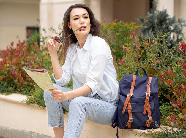 Mujer de alto ángulo con mochila y mapa