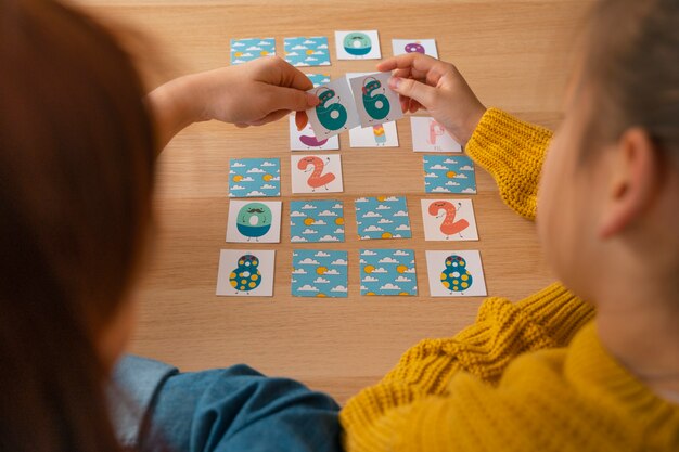 Mujer de alto ángulo y niña jugando juego de memoria