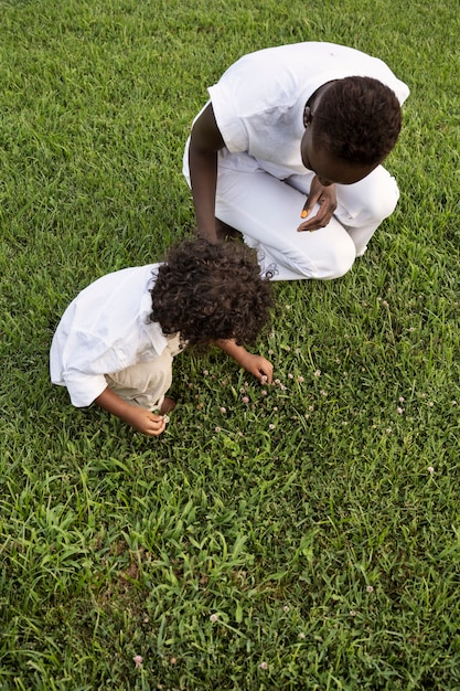 Mujer de alto ángulo y niño recogiendo flores