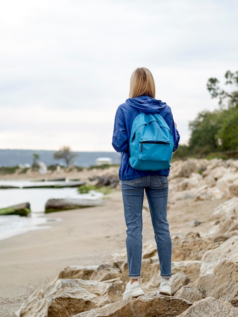 Foto gratuita mujer de alto ángulo en la orilla del mar