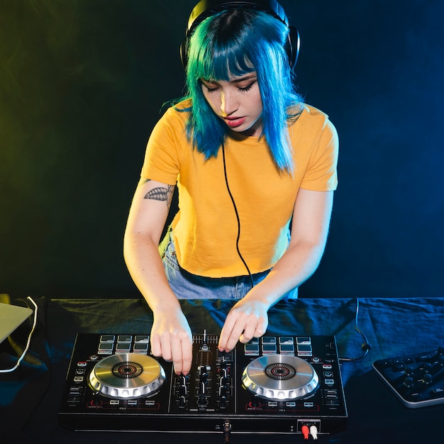 Mujer de alto ángulo en el panel de control del mezclador dj