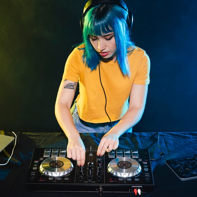 Mujer de alto ángulo en el panel de control del mezclador dj