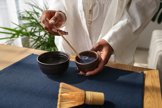 Mujer de alto ángulo preparando matcha azul en casa