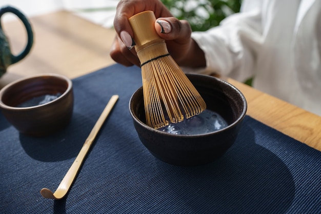 Foto gratuita mujer de alto ángulo preparando matcha azul en casa