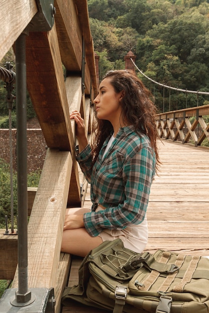 Foto gratuita mujer de alto ángulo en el puente sentado