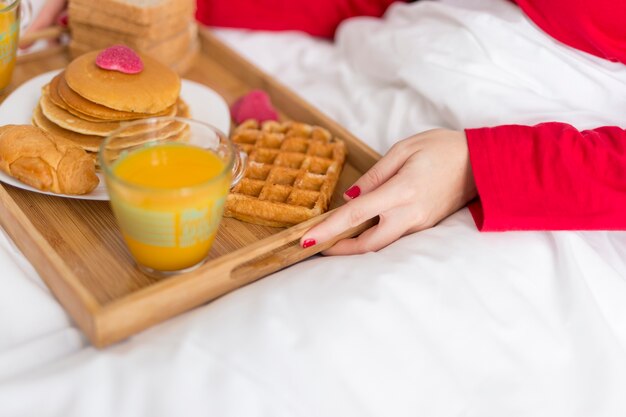 Mujer de alto ángulo que sirve el desayuno en la cama