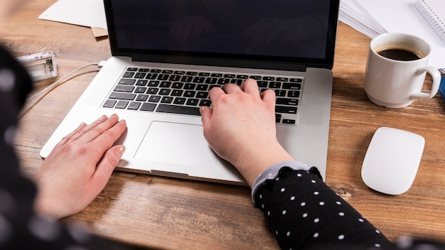 Mujer de alto ángulo que trabaja en la computadora portátil