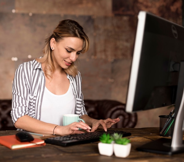 Mujer de alto ángulo que trabaja en la computadora