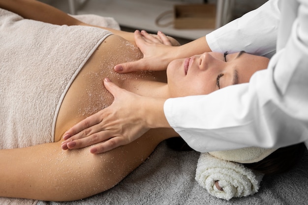 Mujer de alto ángulo recibiendo masajes en el spa