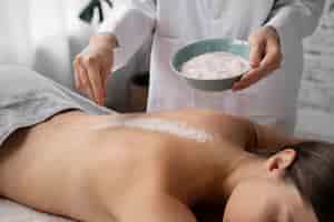 Foto gratuita mujer de alto ángulo recibiendo masajes en el spa