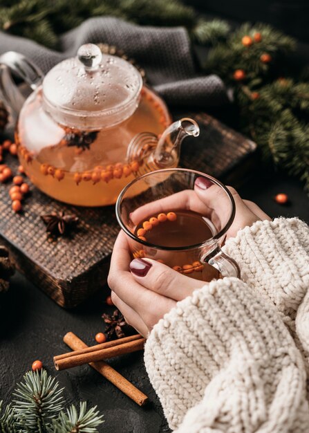 Mujer de alto ángulo sosteniendo glsss con té de espino amarillo