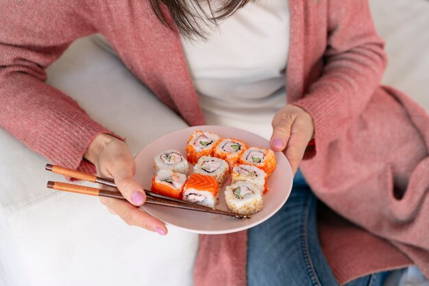 Foto gratuita mujer de alto ángulo sosteniendo sushi