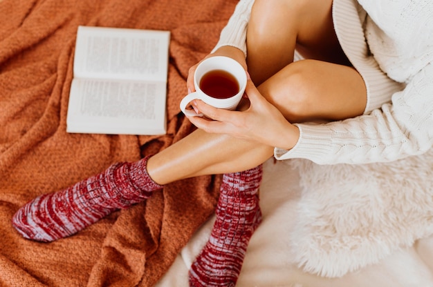 Mujer de alto ángulo sosteniendo una taza de té