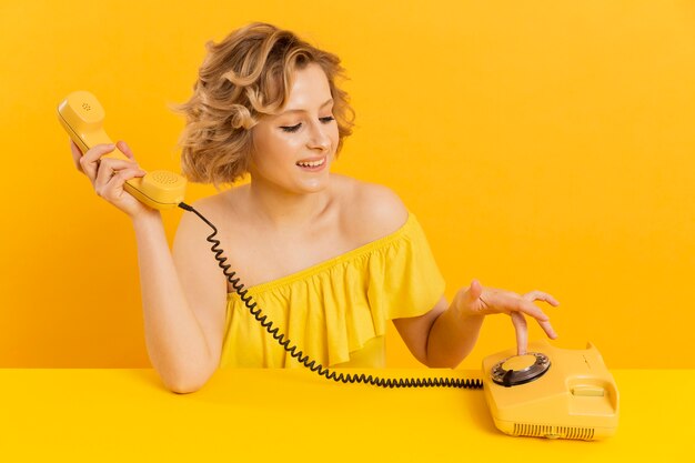 Mujer de alto ángulo con teléfono antiguo