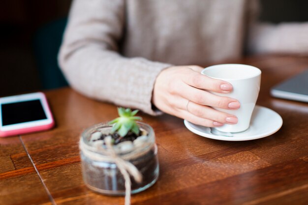 Mujer de alto ángulo tomando café