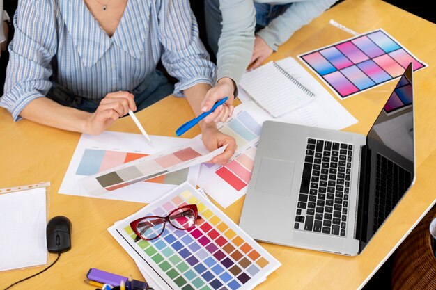 Mujer de alto ángulo trabajando con paletas de colores.