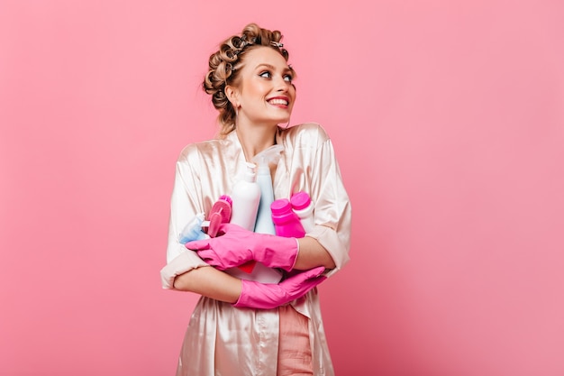 Mujer ama de casa alegre en bata rosa con detergente