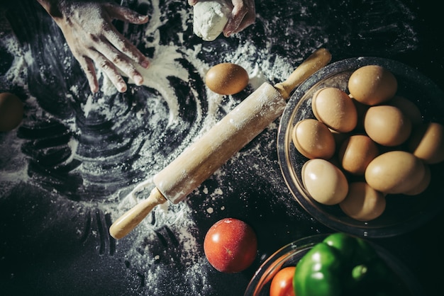 Foto gratuita la mujer amasa la pasta para hacer la pizza en de madera. concepto de cocina