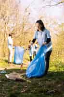 Foto gratuita mujer ambientalista recogiendo basura del suelo para combatir la contaminación