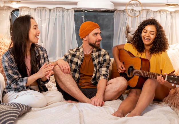 Foto gratuita mujer y amigos tocando la guitarra