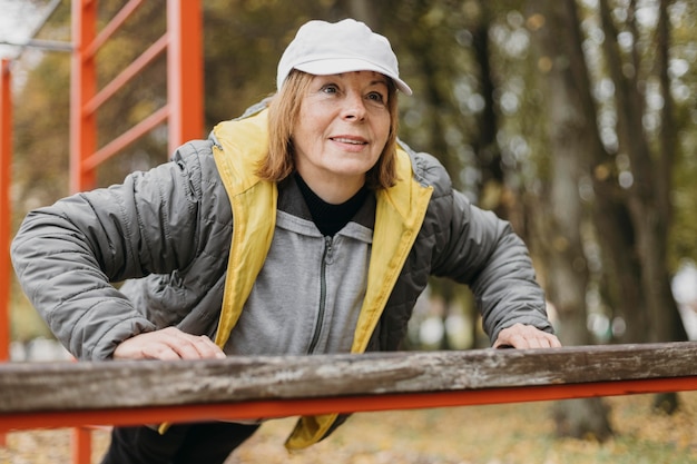 Mujer anciana sonriente trabajando al aire libre