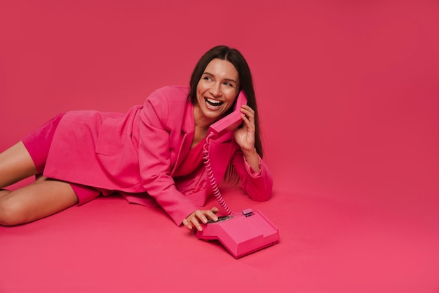 Mujer de ángulo alto posando con traje rosado