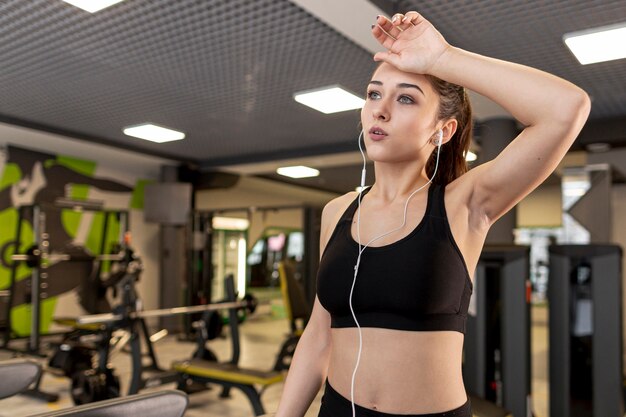 Mujer de ángulo bajo con auriculares cansados