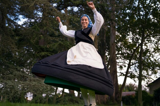 Mujer de ángulo bajo bailando folk