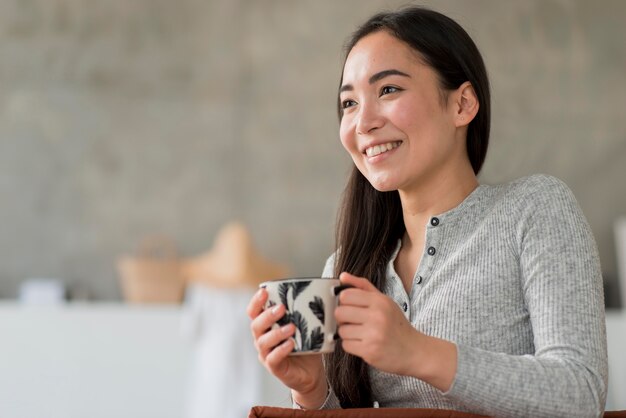 Mujer de ángulo bajo bebiendo té