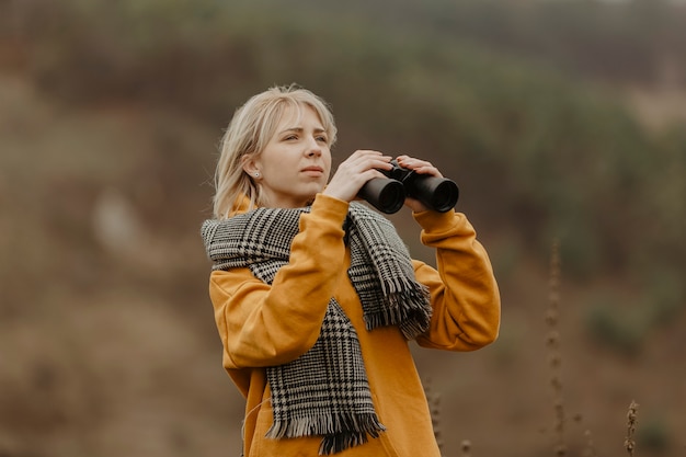 Foto gratuita mujer de ángulo bajo con binoculares